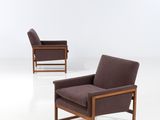 two brown chairs in a white room with a white floor