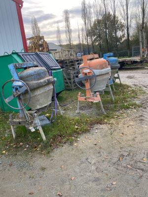 two old cement mixers on the side of the road