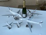 une bouteille de champagne posée sur une table, à côté d'un tas de maquettes d'avions