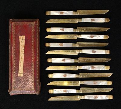 several knives are lined up in a row next to a red box