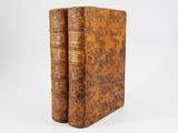 a pair of old books sitting on top of each other
