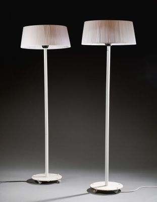 a pair of white lamps sitting on top of a table next to each other