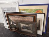 a pile of framed art on the floor next to a door