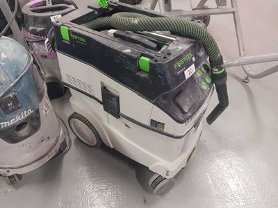 deux aspirateurs posés par terre dans une pièce