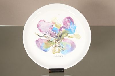 une assiette blanche sur laquelle est représentée une fleur