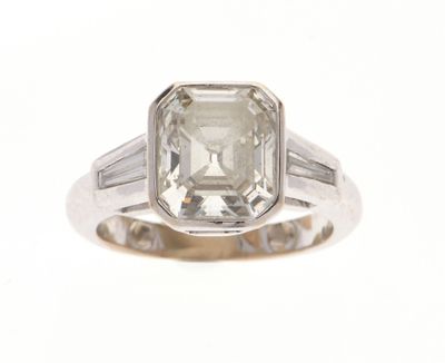 une photo d'une bague en diamant avec un diamant taille baguette au centre