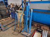 an image of a garage with a blue cart and some tires