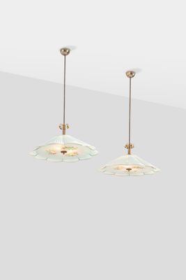 a pair of glass pendant lights hanging from a ceiling