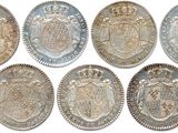 six silver coins with different designs on them on a white background