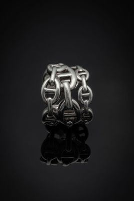 gros plan d'une bague en argent sur une surface noire