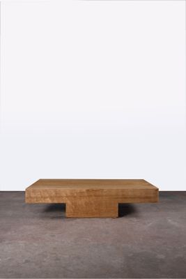 une photo d'une table basse en bois posée sur un sol en béton