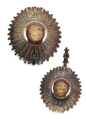 une paire de motifs en forme de rayons de soleil en laiton antique sur fond blanc