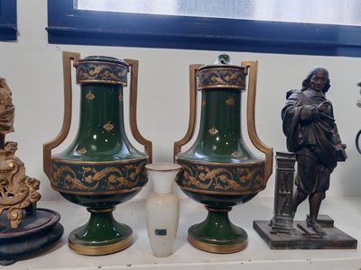 trois vases posés sur une étagère à côté d'une statue