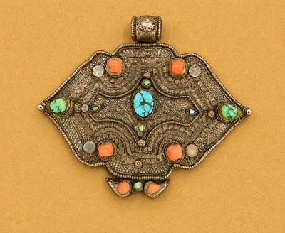 un gros plan d'un pendentif en argent orné d'une pierre turquoise au centre