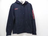 a close up of a blue hoodie with a red logo on it