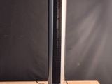 a black and silver tower fan sitting on a wooden table