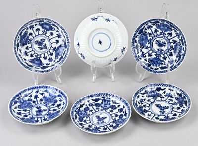 six assiettes bleues et blanches et un plat de service sur pied