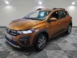 la voiture orange est garée sur le sol en damier d'un garage