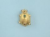 an image of a gold frog charm with a green stone in its mouth