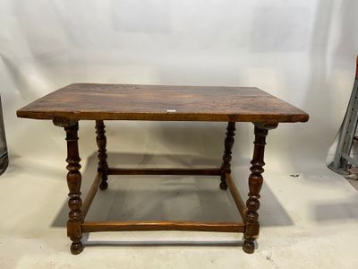 une vieille table en bois posée sur un sol blanc