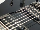 a close up of a black electric guitar on a white background