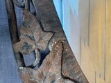 a close up of a wooden bench with a leaf design on it