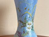 un vase bleu avec des fleurs posé sur une table