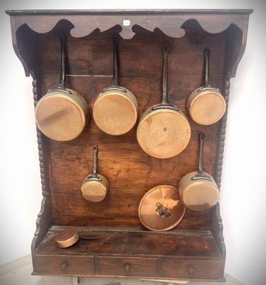 a wooden shelf with pots and pans hanging on it