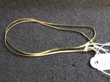 gros plan sur un collier en or portant une étiquette