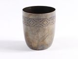 un vase en argent orné d'un motif sur fond blanc