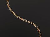 a gold bracelet with multi colored stones on a black background