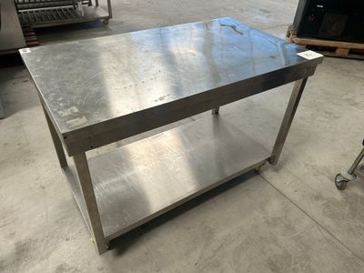 une table en acier inoxydable au milieu d'un entrepôt
