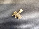 un petit pendentif en forme de papillon doré sur fond noir