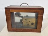 a small wooden box with a clock inside of it