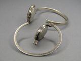 paire de bagues en argent avec un fermoir en argent sur un fond gris
