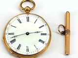 a gold pocket watch with roman numerals and a key