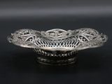 a close up of a silver bowl on a black surface