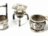 three silver objects sitting on a white surface