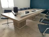une longue table sur laquelle est posé un ordinateur portable, au milieu d'une pièce
