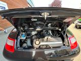 a black car with its hood open and the engine in the trunk