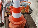 orange and white traffic cone sitting on top of a pile of orange and white cones