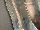 a silver plate with two spoons on it on a table