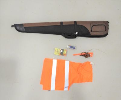 un gilet orange, une paire de chaussures orange et un pistolet posé sur une table