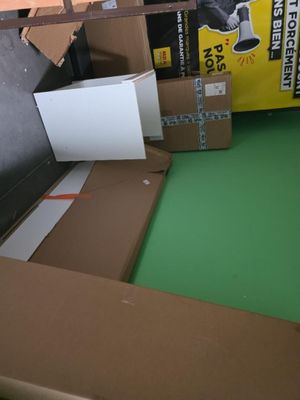 une boîte en carton posée sur le sol à côté d'une boîte en carton