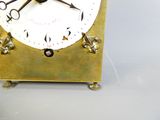 une horloge dorée avec un cadran blanc et des aiguilles noires