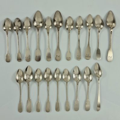 six cuillères et deux cuillères sont alignées sur une surface blanche