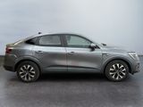 the silver suv is parked in a parking lot on a cloudy day