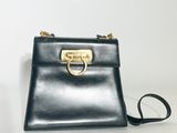 un sac à main noir muni d'un anneau doré sur la poignée
