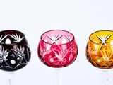 four wine glasses lined up in a row on a white surface