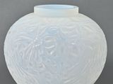a white vase with a blue lid sitting on a table